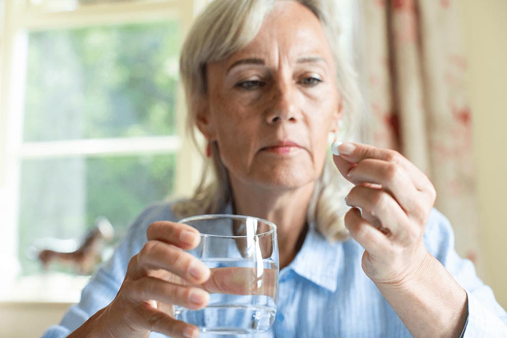 vrouw neemt pil met glas water