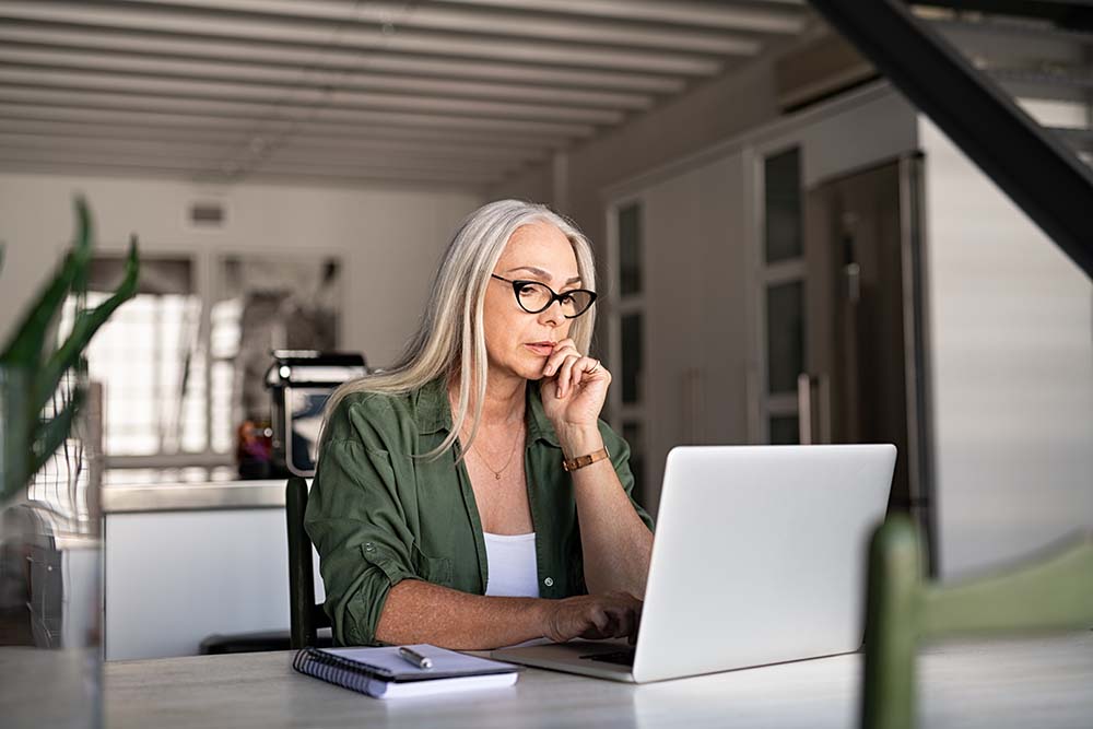 Vrouw thuis achter laptop