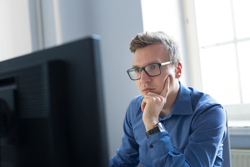 jonge man aan beeldscherm jonge man aan beeldscherm