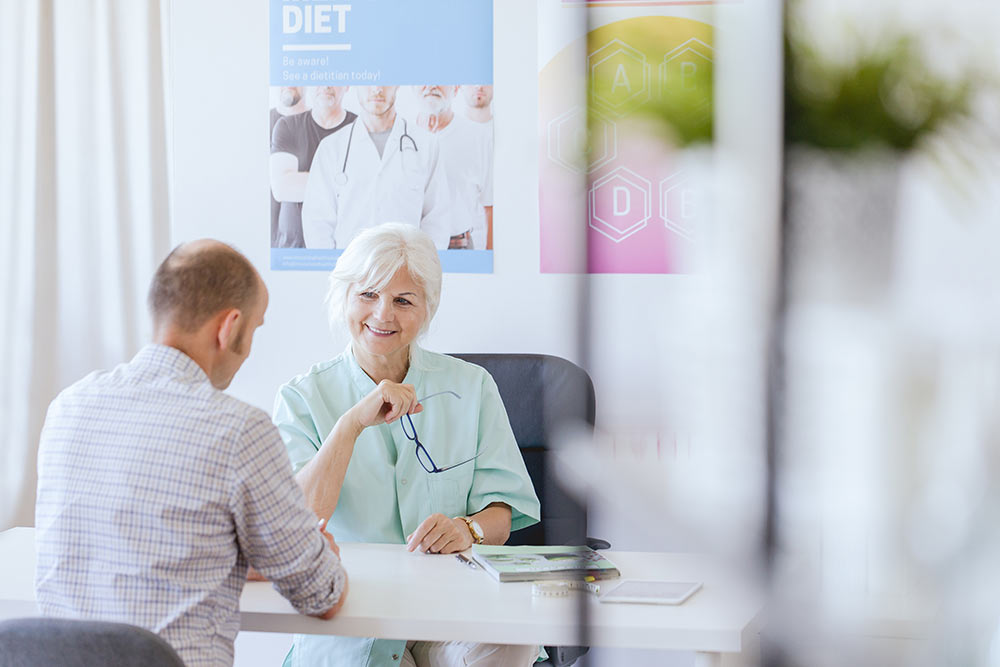 man op consult bij diëtist