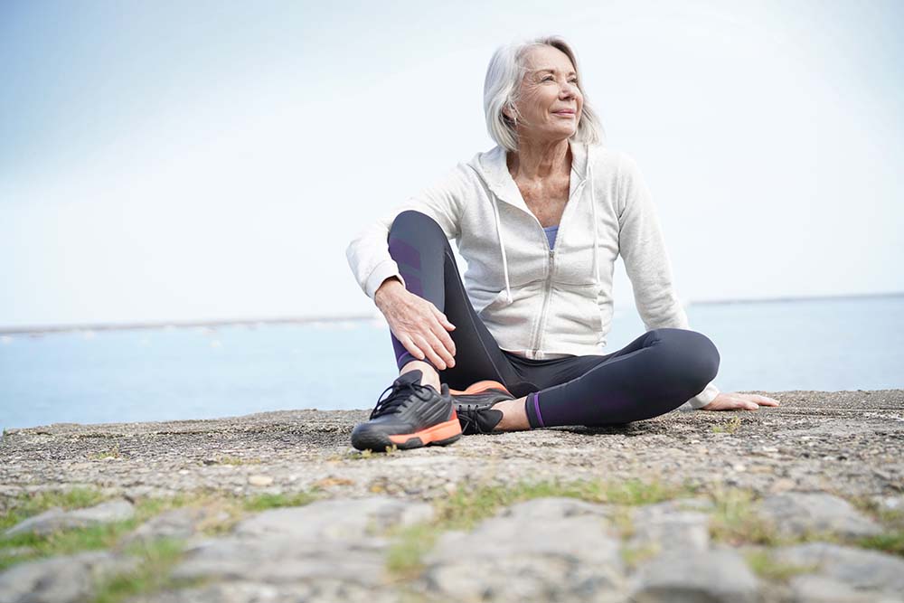 oudere vrouw in sportkleding op rots